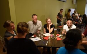 A gathering of participants at Fresh Ground Café, engaged in discussions during the Philosophy in the Pub session for the Summer Institute in Grassroots Sustainability.